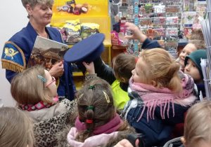 Dzieci przymierzają czapkę listonosza