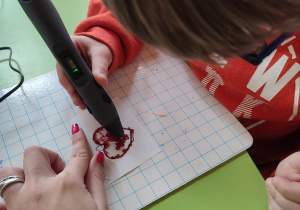 Dziecko rysuje serce długopisem