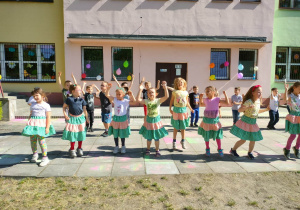 Dziewczynki ubrane w kolorowe spódniczki prezentują taniec
