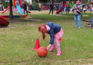Dziewczynka toczy piłkę