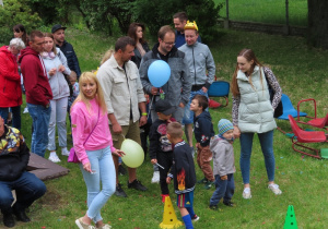 Rodzice i dzieci trzymają balony