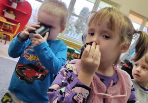 Dziewczynka poznaje zapachy wydobywające się z woreczków zapachowych.