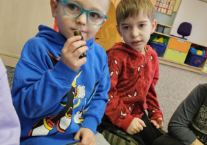 Chłopiec poznaje zapachy wydobywające się z woreczków zapachowych.