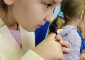 Dziewczynka poznaje zapachy wydobywające się z woreczków zapachowych.