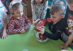 Dzieci z grupy "Biedronki" przygotowują sałatkę dla rodziców.