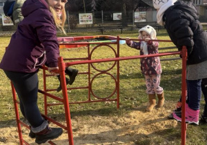 Trzy dziewczynki baią się na drabince.