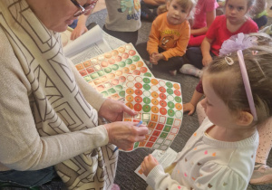 Nauczycielka rozdaje dzieciom naklejki