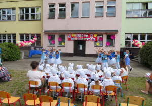 Motylki w strojach smerfów prezentują przygotowany taniec.