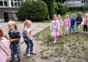 Dzieci przechodzą pod liną w ogrodzie przedszkolnym.