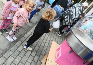 Dzieci czekają w kolejce po watę cukrową.