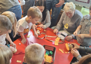 Dzieci z rodzicami wykonują ziemniaczane ludziki.