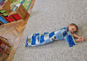 Chłopiec zawinięty w koc.