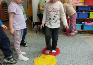 Dzieci pokonują sensoryczny tor przeszkód.