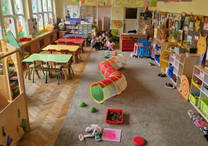 Dzieci pokonują sensoryczny tor przeszkód.