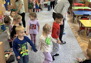 Dzoeci wspólnie tańczą w kole.