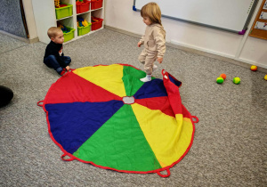 Chłopcy bawią się z wykorzystaniemkolorowej chusty animacyjnej.