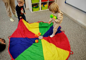 Chłopcy bawią się z wykorzystaniemkolorowej chusty animacyjnej.