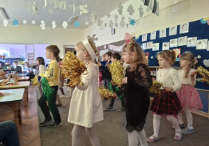 Dzieci z grupy Biedronek wykonują taniec z kolorowymi pomponami.