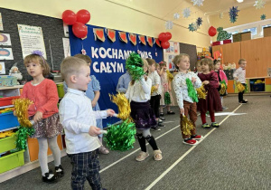 Dzieci z grupy Biedronek wykonują taniec z kolorowymi pomponami.