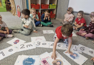 Dzieci omawiają ilustracj obrazujące różne emocje.