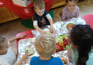 Dzieci przygotowują kanapki dla rodziców.