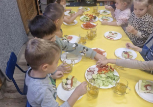 Dzieci przygotowują kanapki dla rodziców.